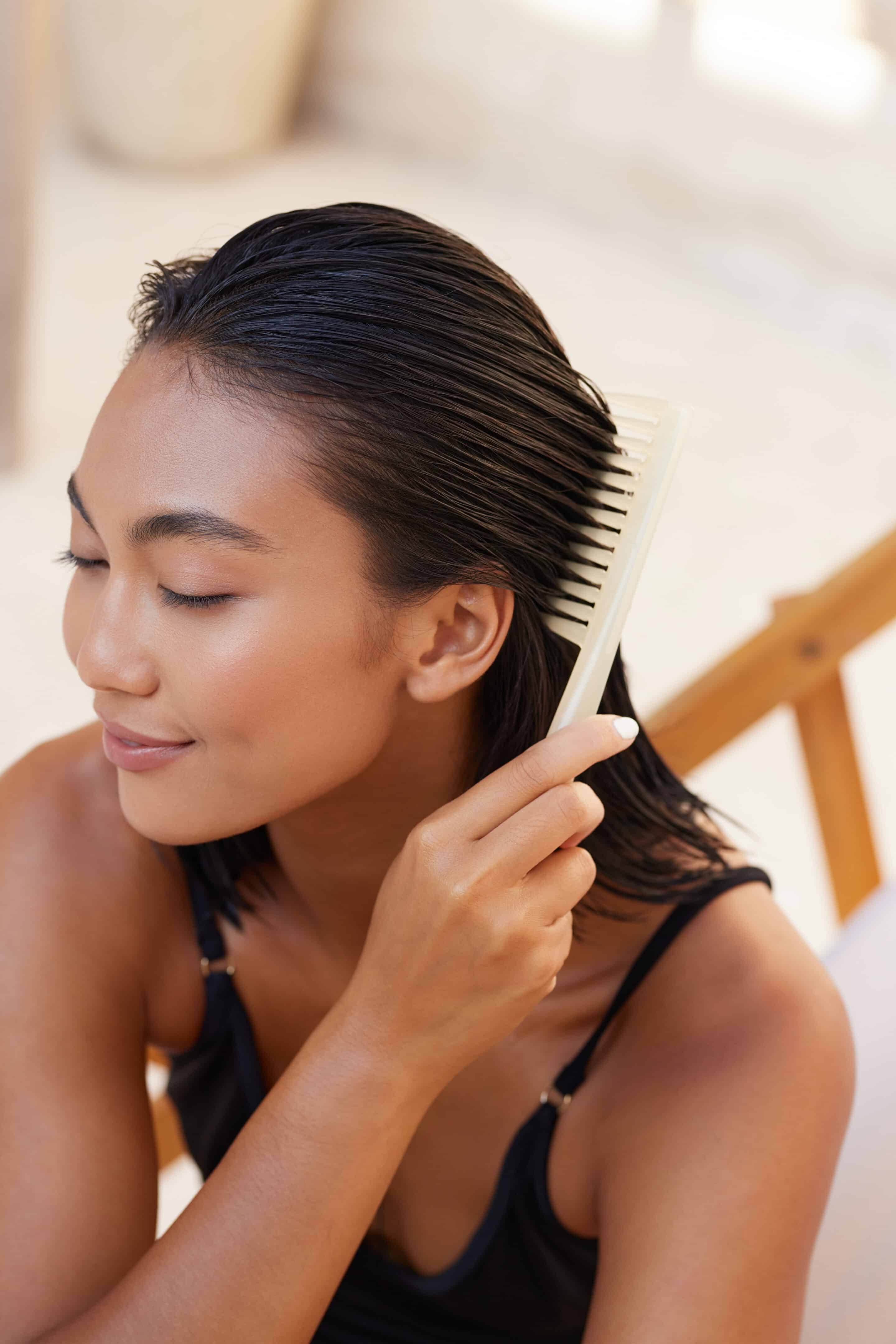 Woman Combing Wet Hair Outdoors for Smooth and Healthy Look